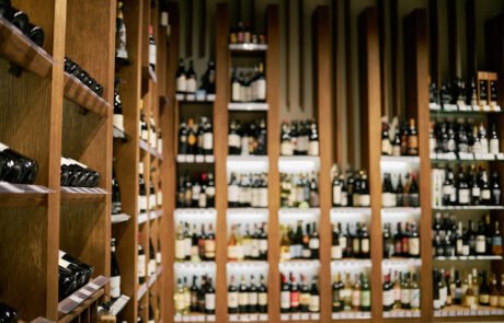 Rows of Bottled Wine in Wooden Shelves in Store Display