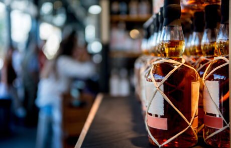 selective focus of whiskey bottles placed in rows on shelf in store
